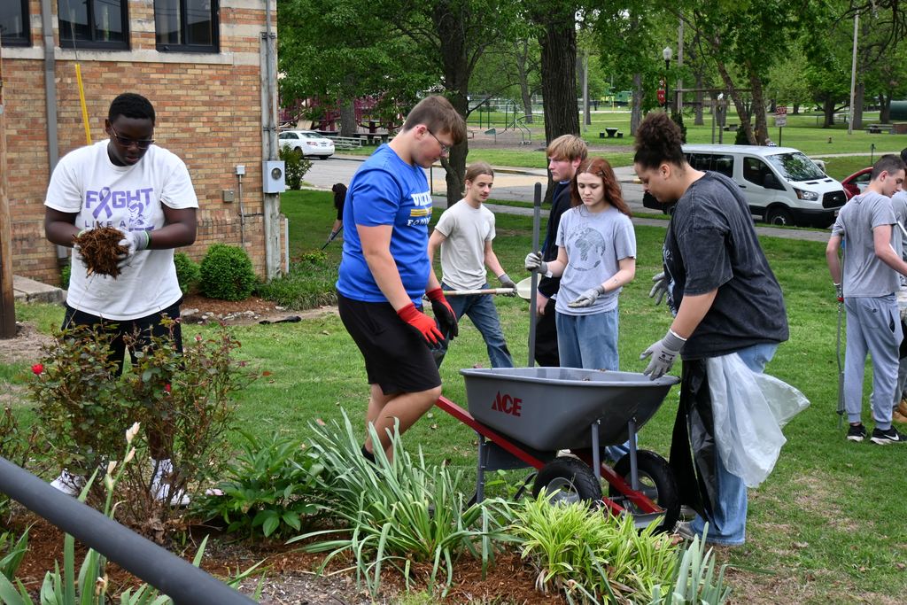 Students mulch a flower bed at the rec.