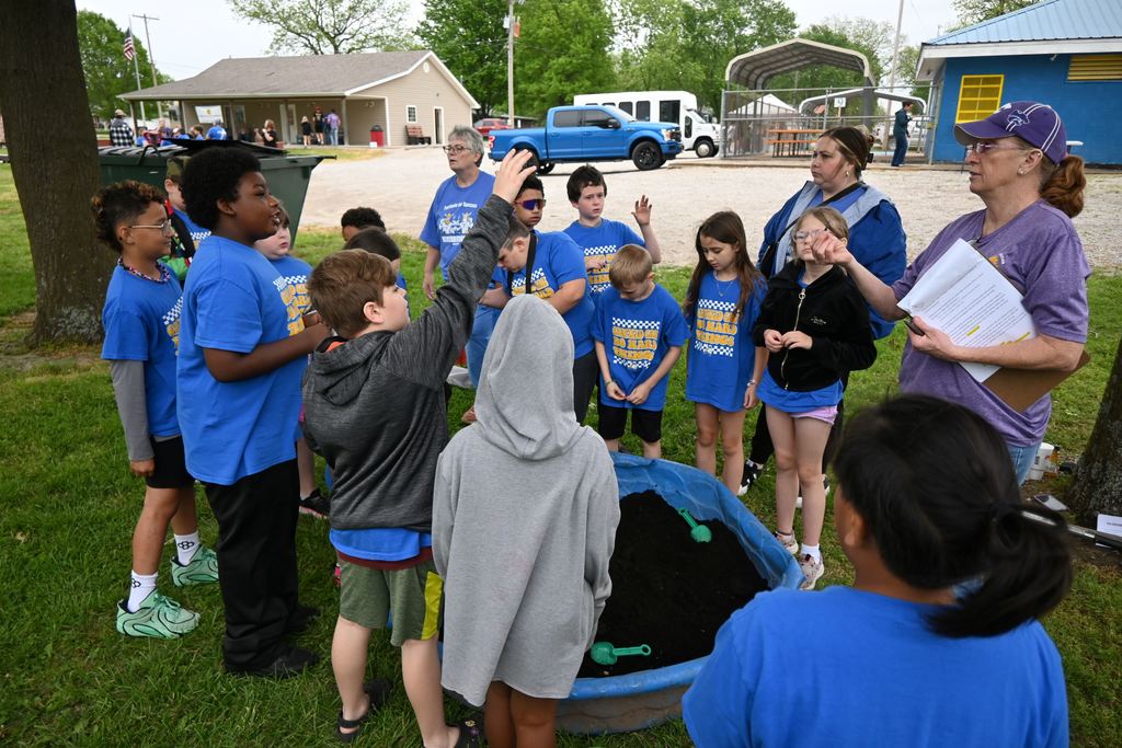 Students raise their hands to answer questions about artifacts.