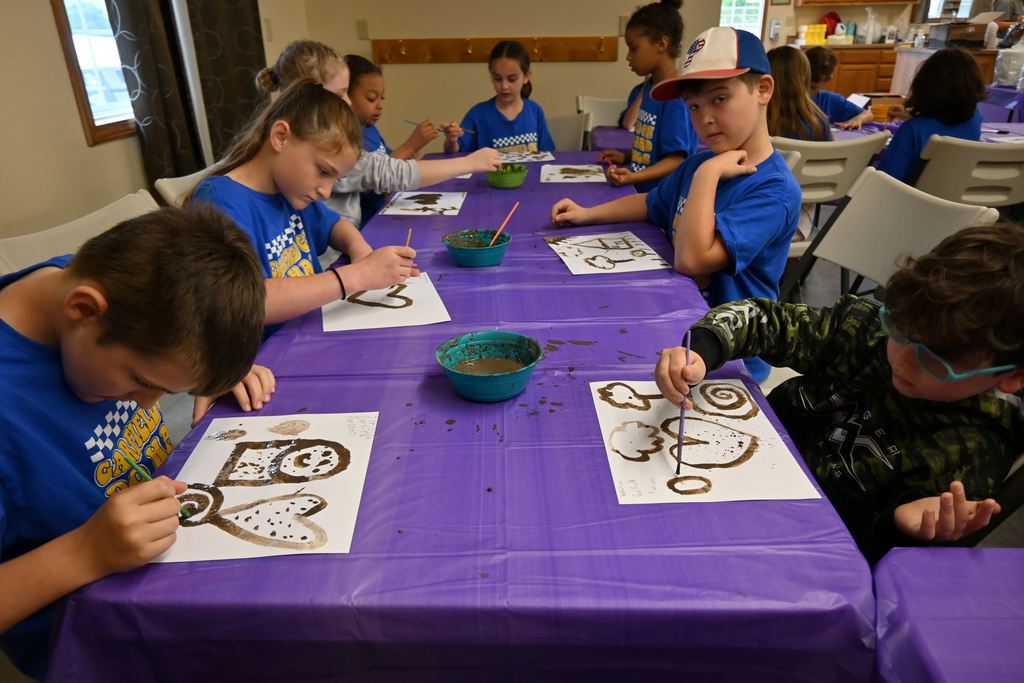 Students paint with soil.