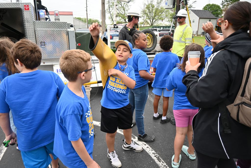 A student tries on a protective sleeve for an electrician.
