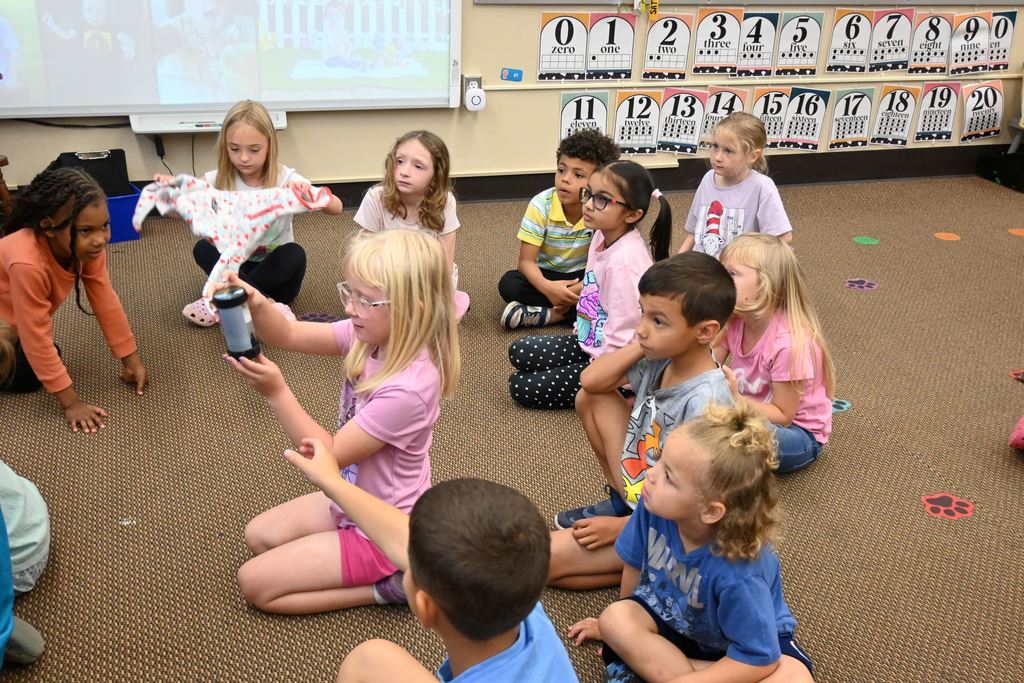 Students try to make a tornado iwith liquid in a container.
