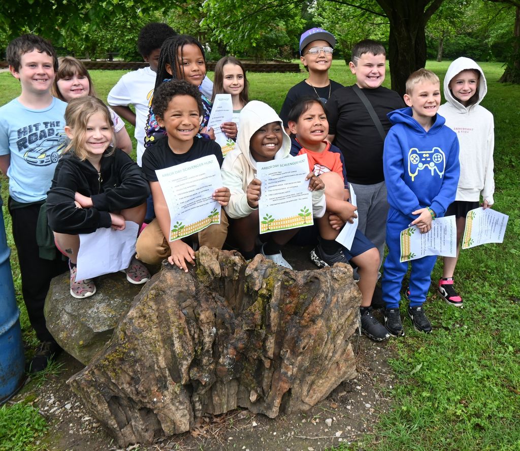 students sit atop a large piece of petrified wood
