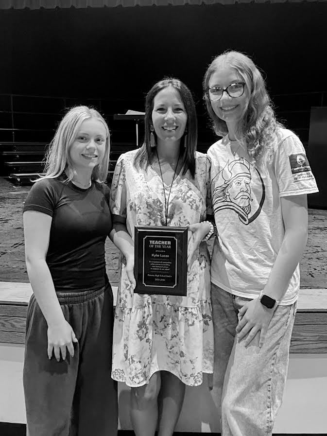 Two students present Lucas her plaque.