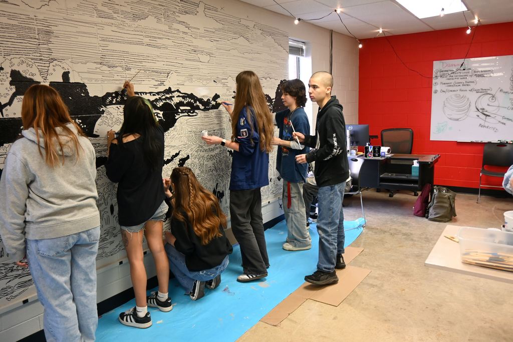 Students paint a mural in the art room.