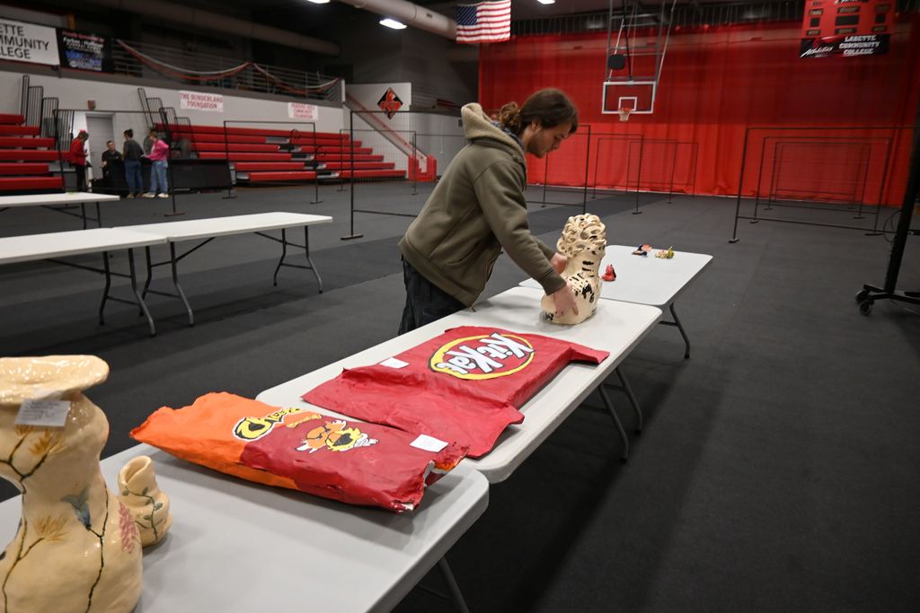 A student places the bust he sculpted on a table.