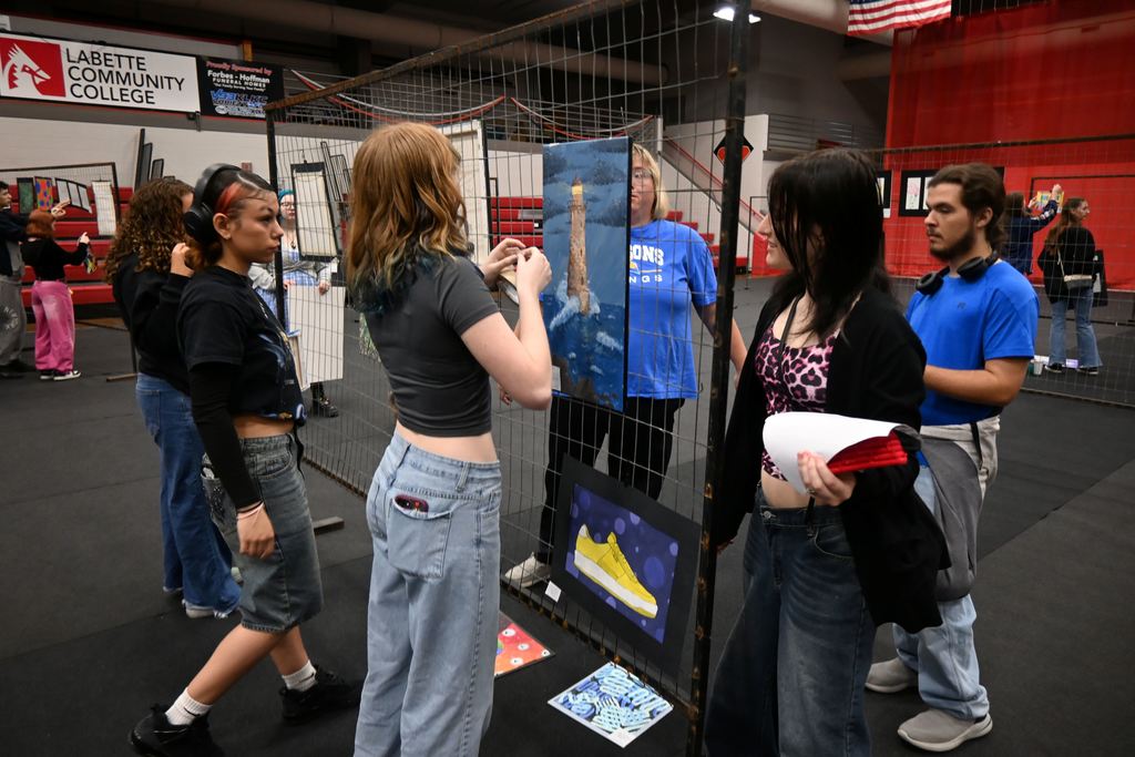 Students hang their paintings for the competition