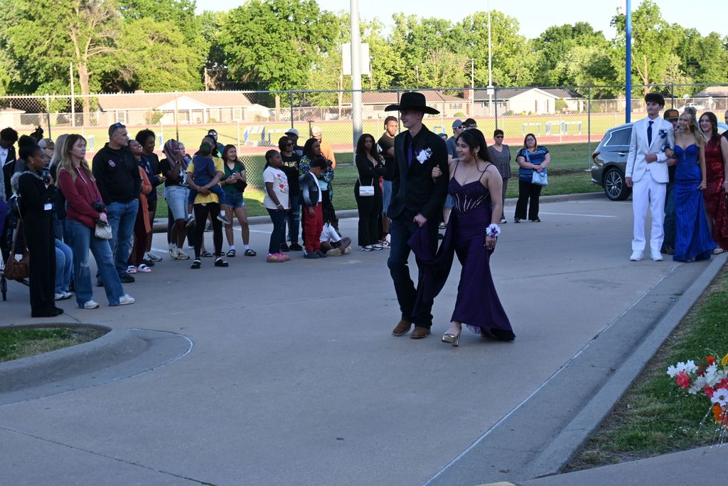 A boy escorts a girl into prom.