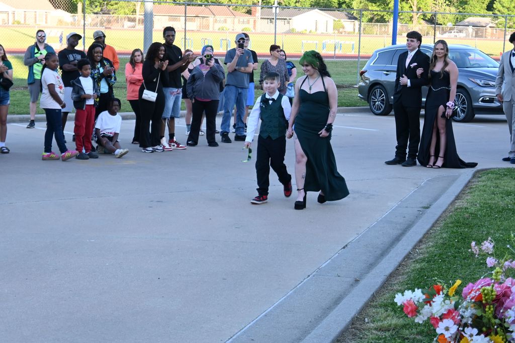 A boy escorts a girl into prom.