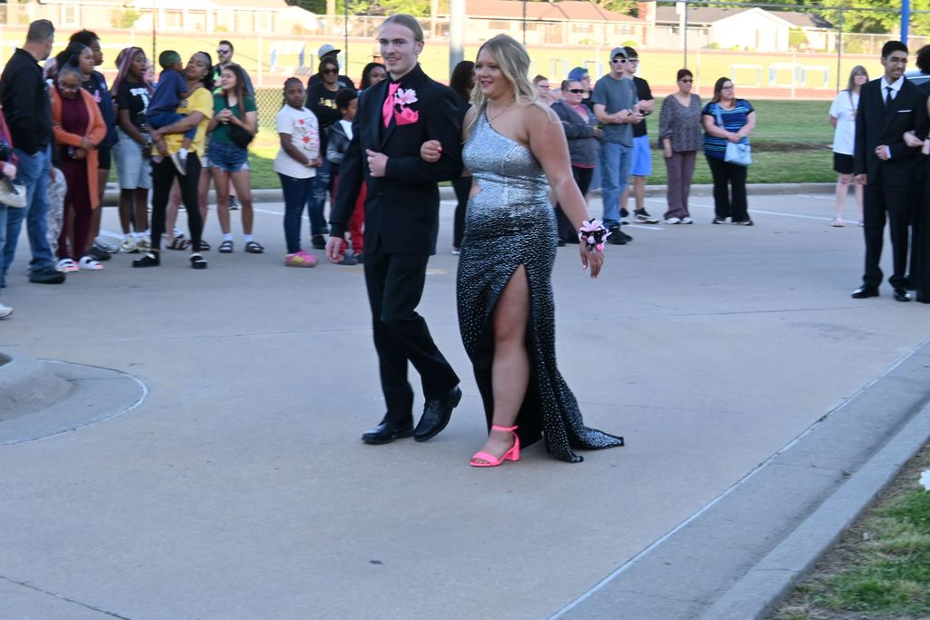 A boy escorts a girl into prom.
