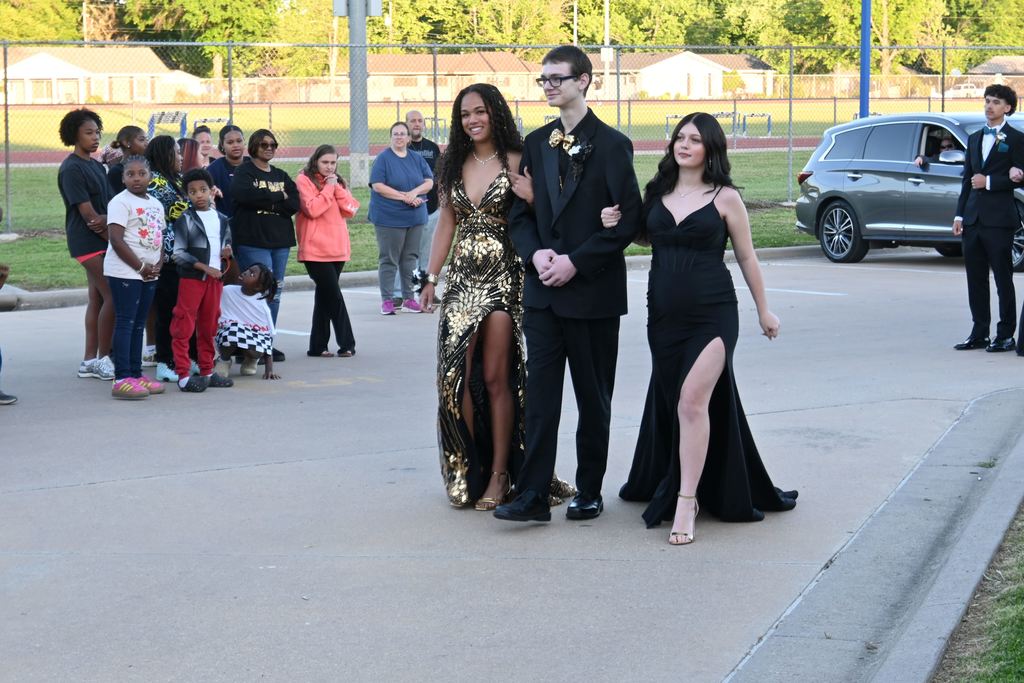 A young man escorts two girls to prom.