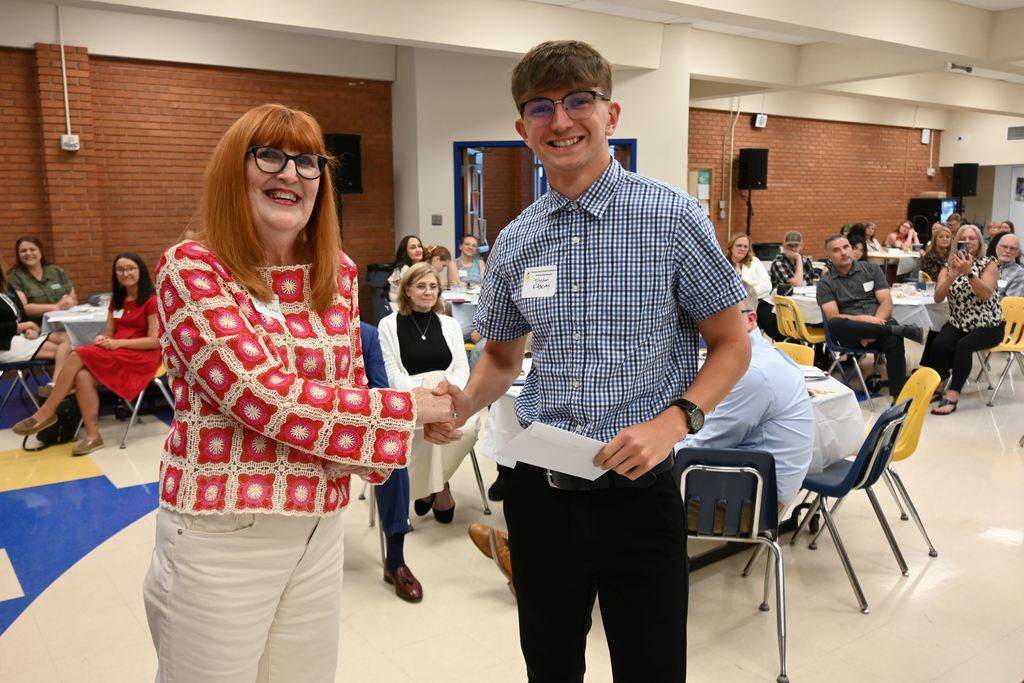 Ruth Kindall presents a scholarship to a young man.