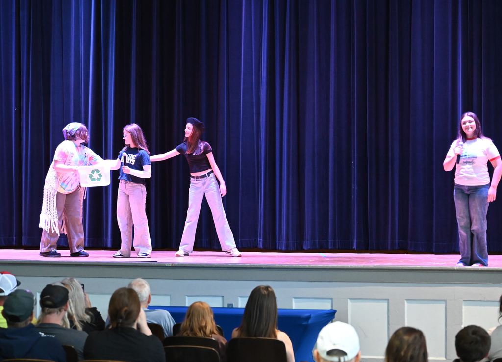 Students act out a scene talking about clubs and organizations.