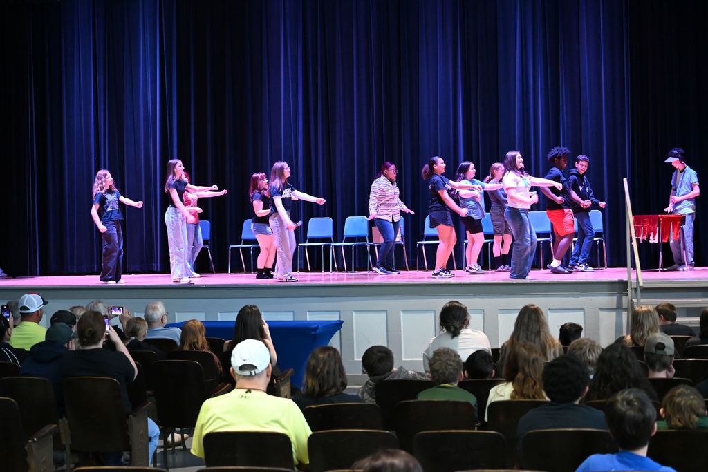 Students act out a scene where they are at a school dance.