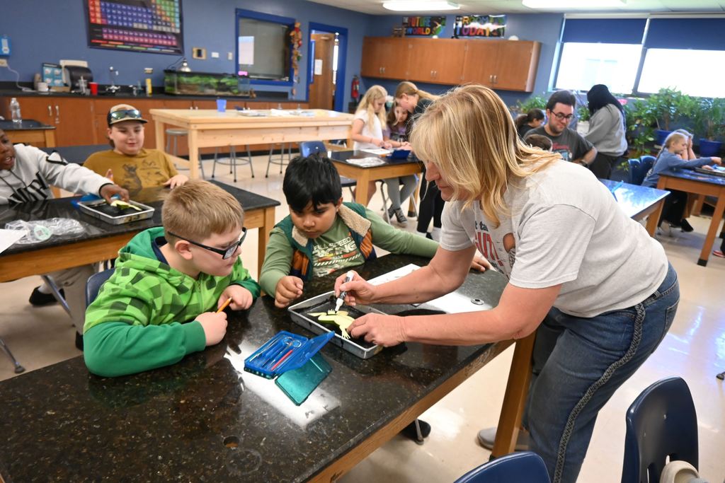 Mrs. Friess draws an I on the synthetic frog, showing wear to cut it.