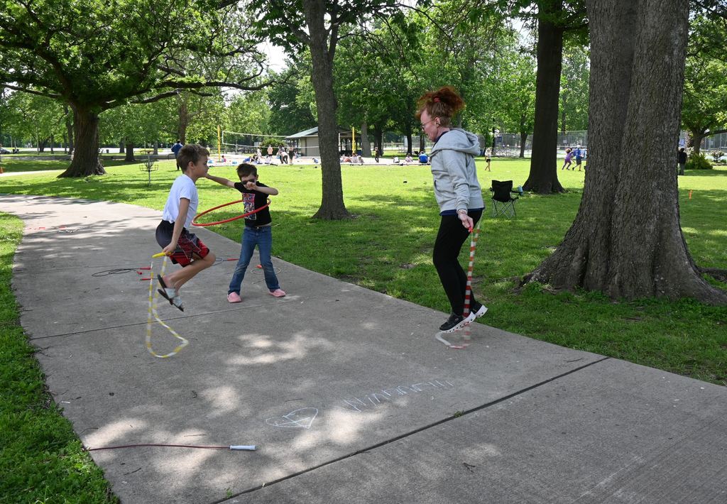 One boy jumps rope with Mrs. Tierney and one hula hoops.