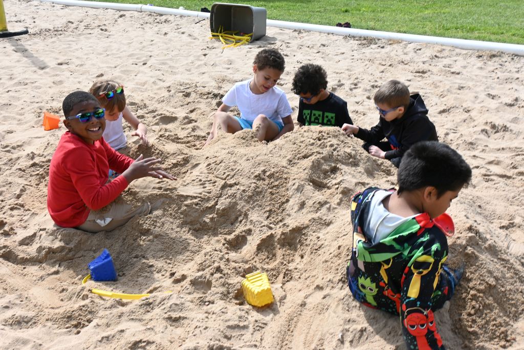 A group of boys play in the sand.
