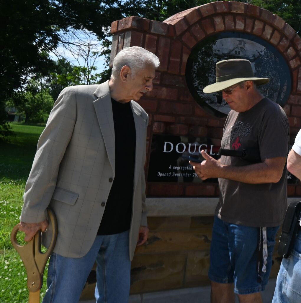 People check out the QR code on the memorial.