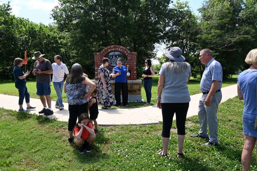 Lori Perkins explains to Liz Cochran about the QR Code  with information on the memorial.