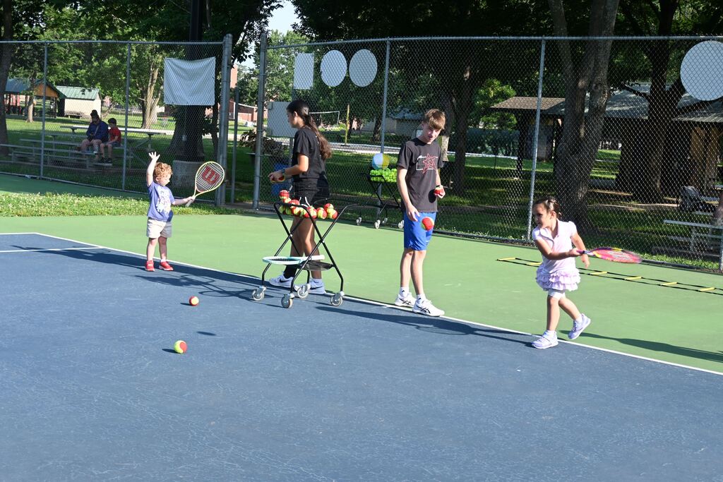 children practice forehand skills with their teachers.