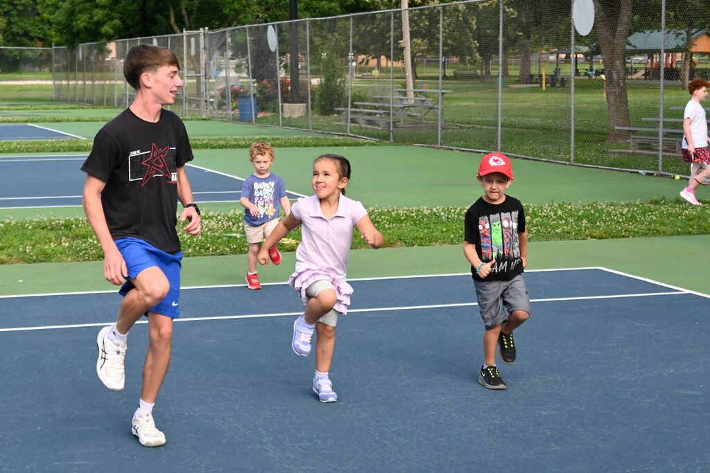 Children do warm ups with their teacher before practice.