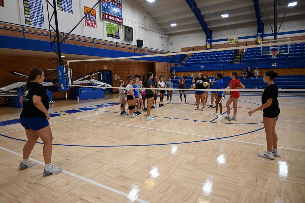 n assistant coach talks to a group of girls.