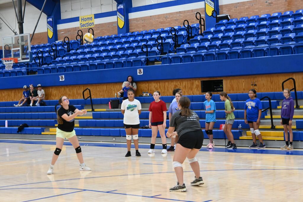 Girls volley the ball learnng control.