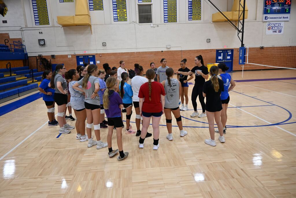 Coach BarrMiller talks to a grup of girls.