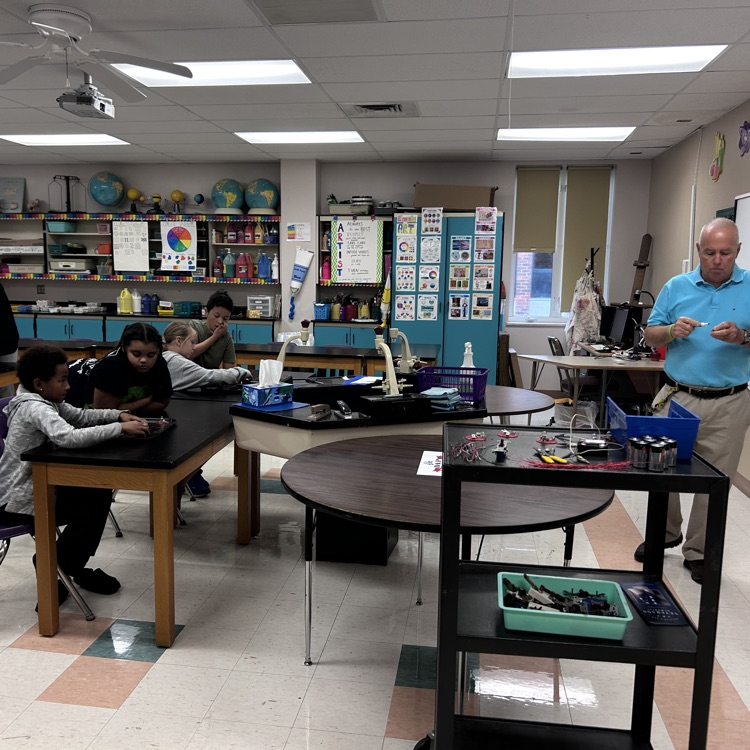 Mr. Duroni demonstrating how to connect the wires with the batteries and bulbs  