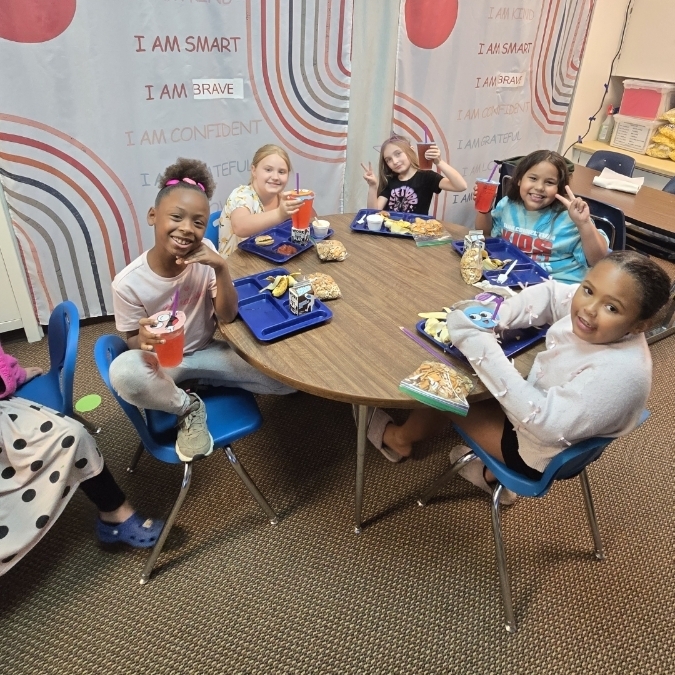 girls sitting at a table smiling