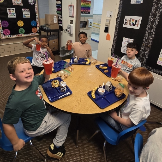 boys sitting at the table enjoying their lunch
