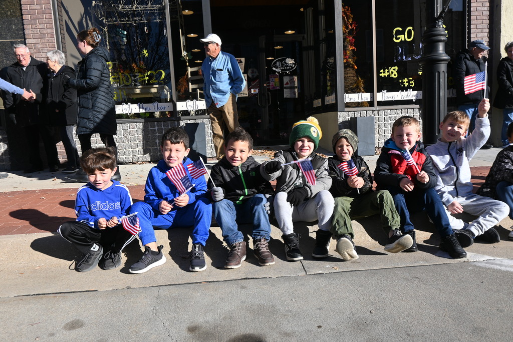 A group of bouys sit on the curb and wave flags.