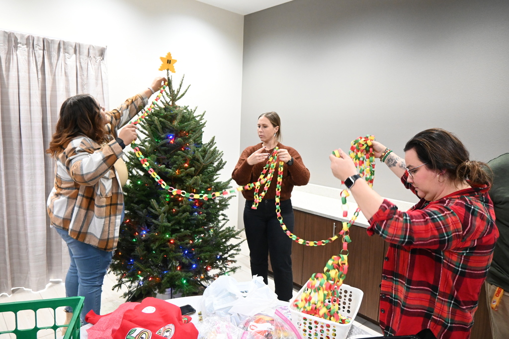 Teachers work on hanging te hand made paper chain.