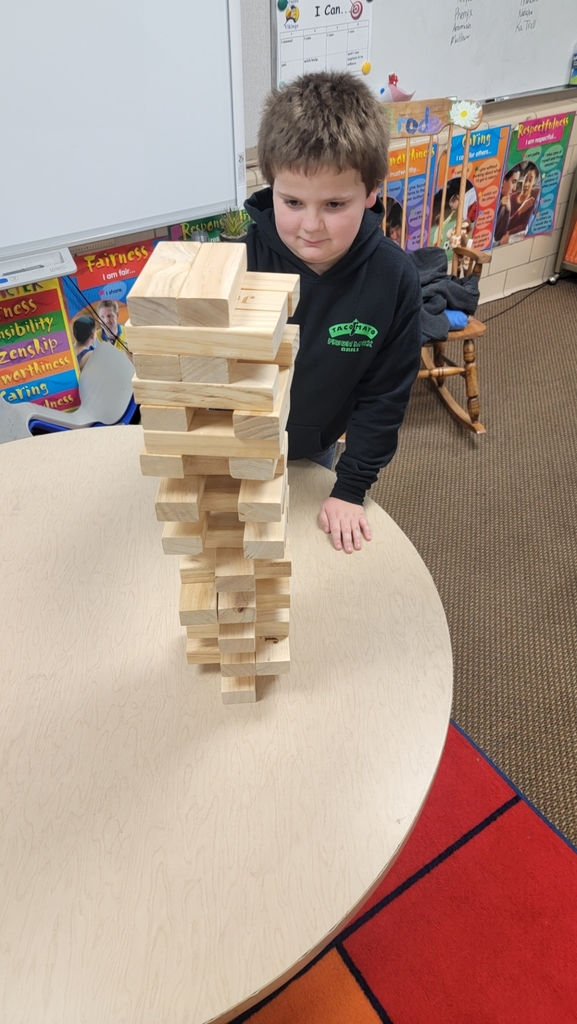 boy in black hoodie looking at the block tower