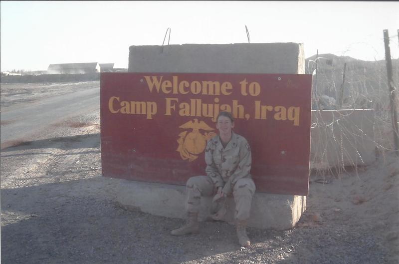Vietti sits in front of a sign for Camp Fallijah.