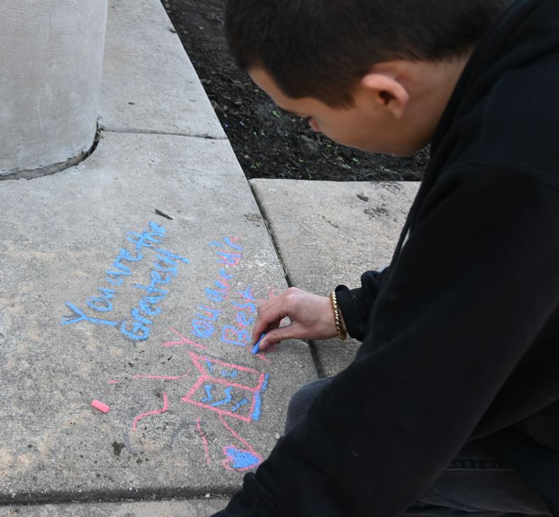 A boy writes quotes and adds art.