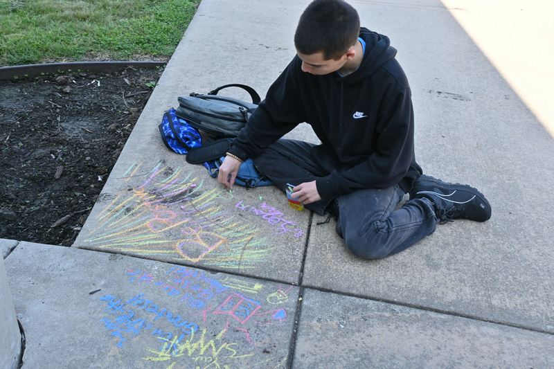 A boy writes quotes and adds art.
