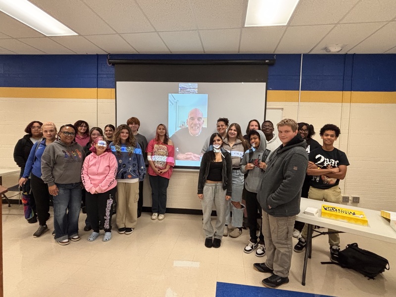 CAMP students stand beside Tad Roach on the screen.