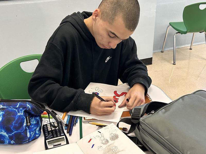A student writes a word in graffiti style.
