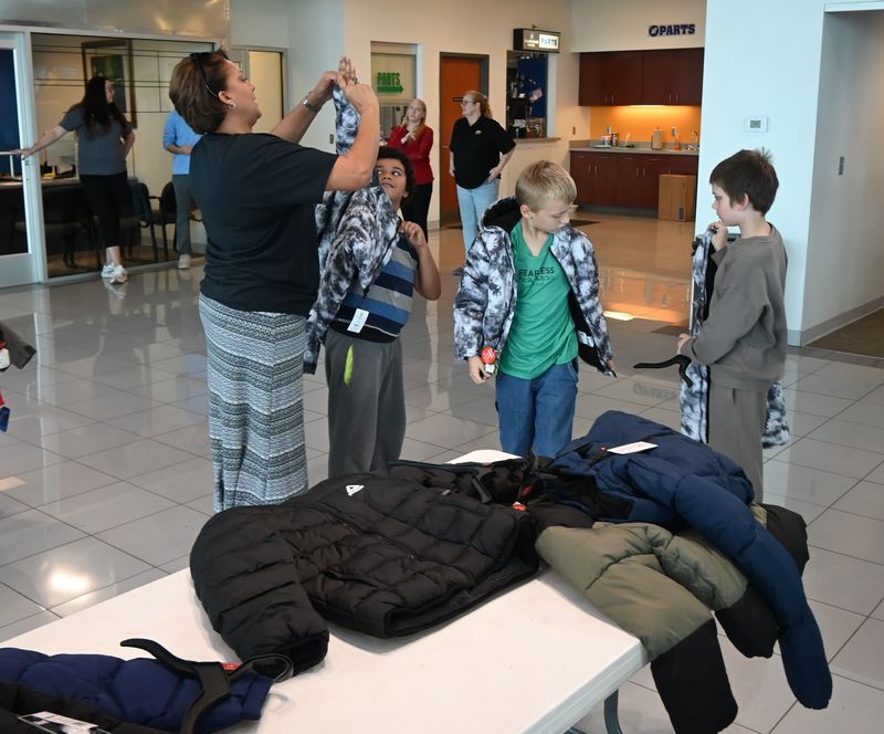 Susan Hill helps a boys with his coat.