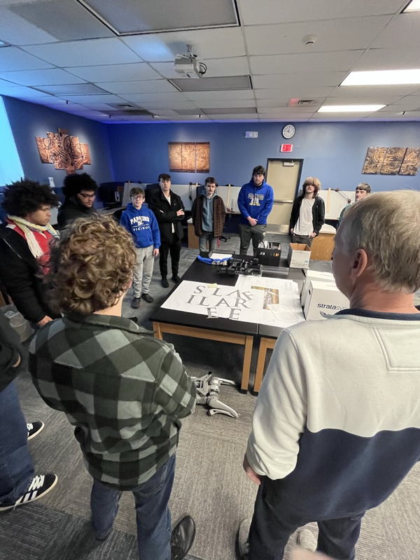 Ducommun engineers talk to students about the titanium letters they will attach to a beam on the veterans memorial. 