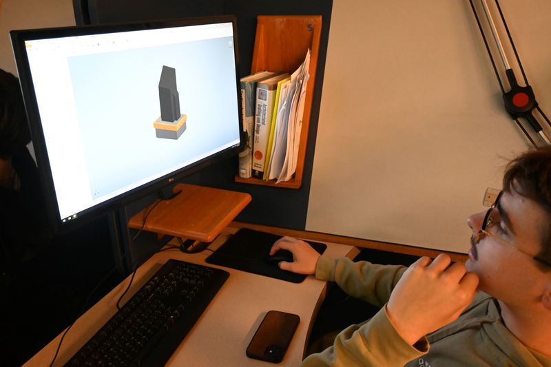 A student goes over the measurements for the concrete slabs that will support the podiums for the veterans memorial.
