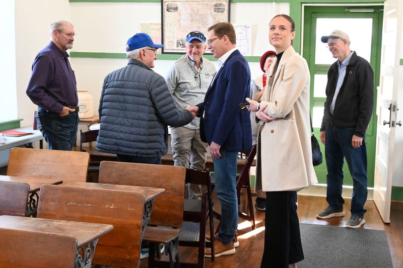 Toland shakes hands with former students.