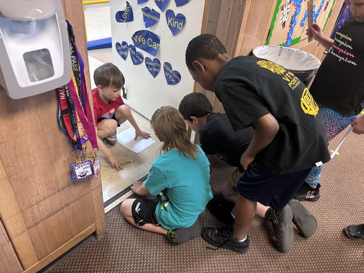 Students measring the doorway of the classroom.