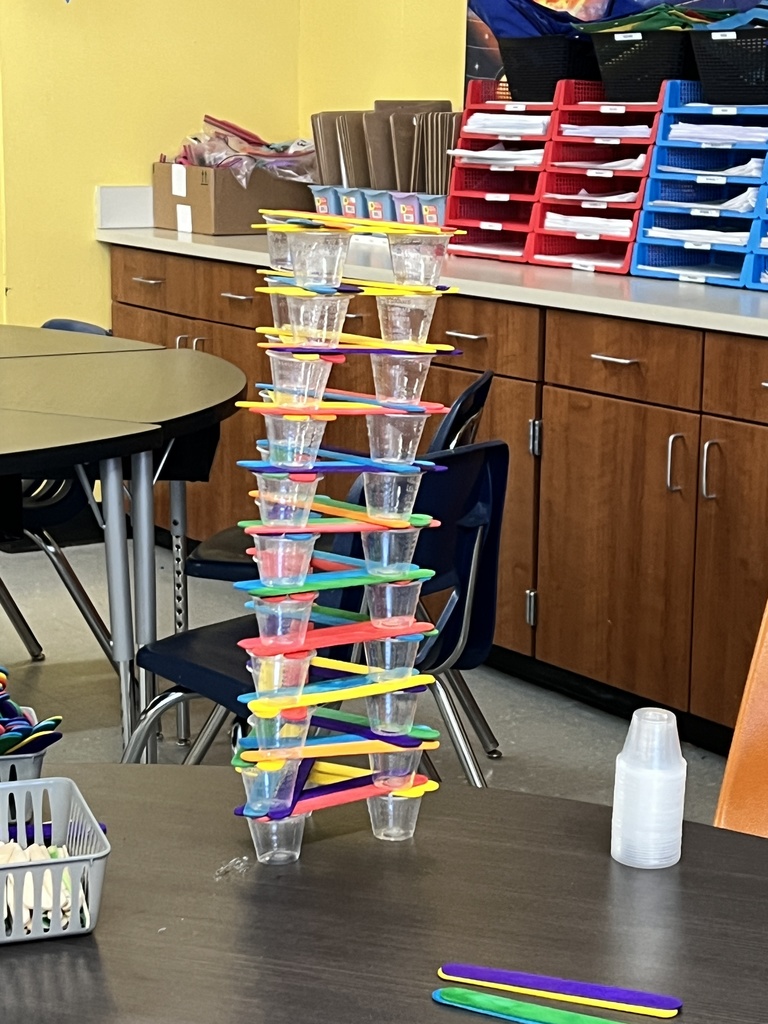  Students engaged in a STEAM-based structural engineering challenge, designing and testing freestanding towers using simple materials to explore stability, force, and collaborative problem-solving.