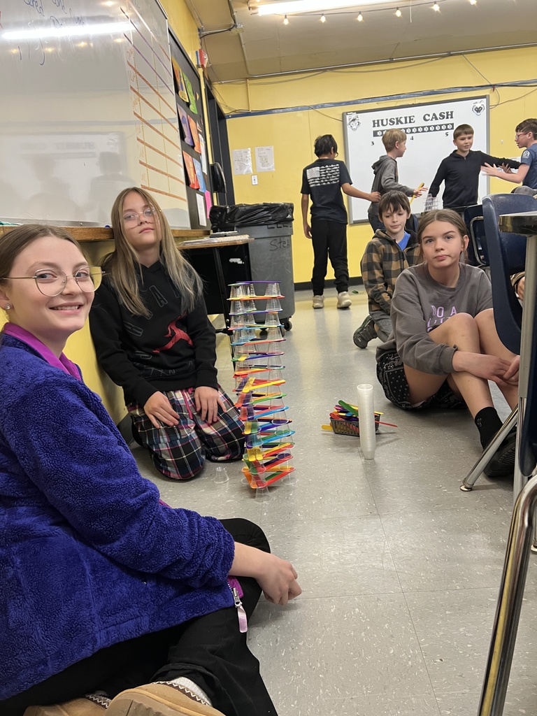  Students engaged in a STEAM-based structural engineering challenge, designing and testing freestanding towers using simple materials to explore stability, force, and collaborative problem-solving.