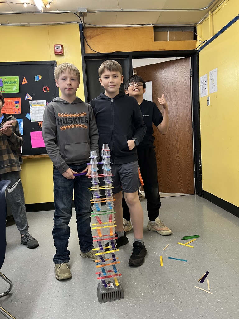  Students engaged in a STEAM-based structural engineering challenge, designing and testing freestanding towers using simple materials to explore stability, force, and collaborative problem-solving.
