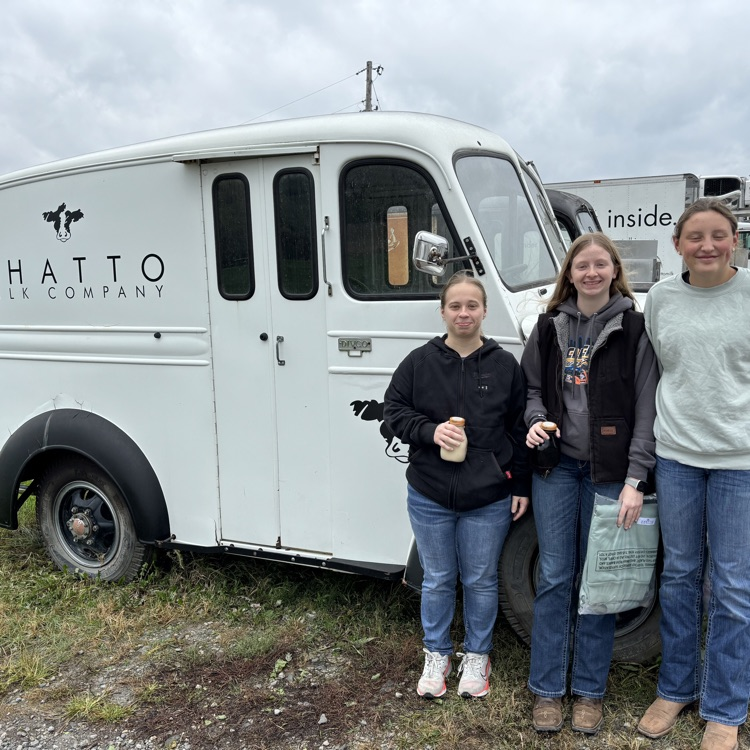 Girls standing next to an old fashioned Shatto Milk Truck