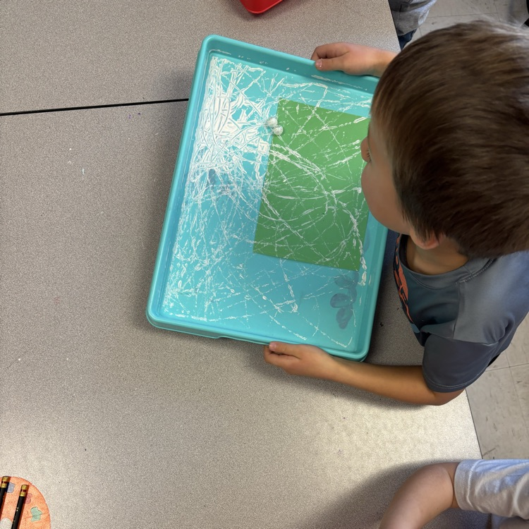 Student painting with marbles