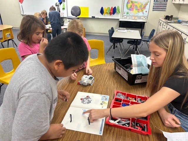 Bailey points out how to attach a couple of robotic pieces together. 