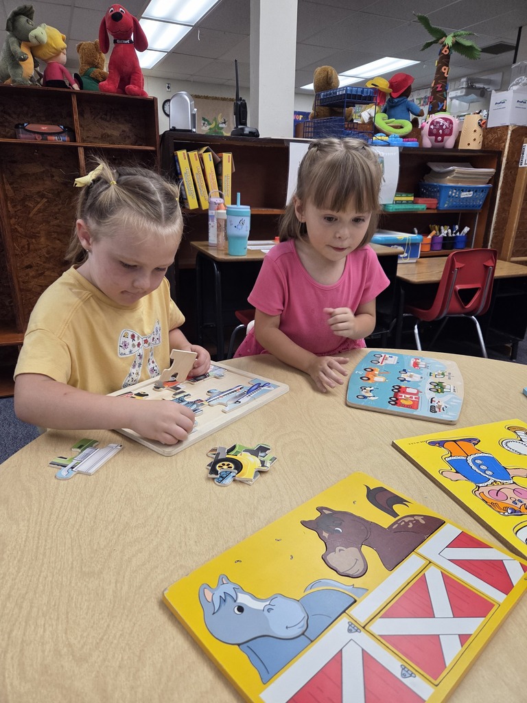 Anna and Lily putting puzzles together.